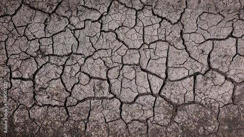 Dark dry cracked earth background. Dried mud texture.