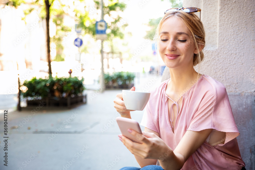 Young woman having cafe and text messaging while sitting at outdoor cafe Young woman having cafe and text messaging while sitting at outdoor cafe