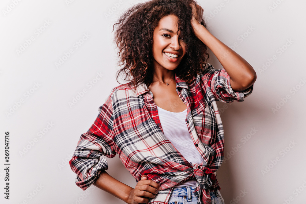 Jocund young woman in red shirt standing in confident pose. Indoor photo of cheerful brunette girl isolated on white background. Jocund young woman in red shirt standing in confident pose. Indoor photo of cheerful brunette girl isolated on white background.