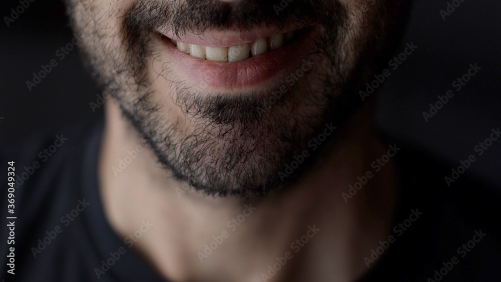 Close up of smiling man. Caucasian guy is smiling, close up of the mouth. Low key light, shallow depth of field Close up of smiling man. Caucasian guy is smiling, close up of the mouth. Low key light, shallow depth of field