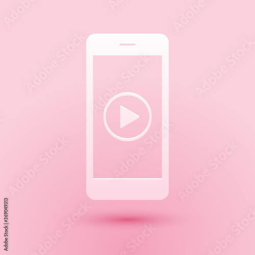 Paper cut Smartphone with play button on the screen icon isolated on pink background. Paper art style. Vector.