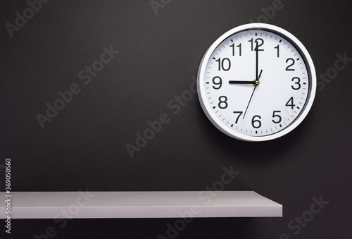 clock and shelf at wall background
