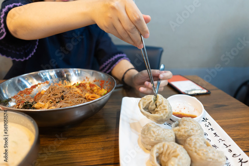 Woman eating steamed dumpling at restaurant