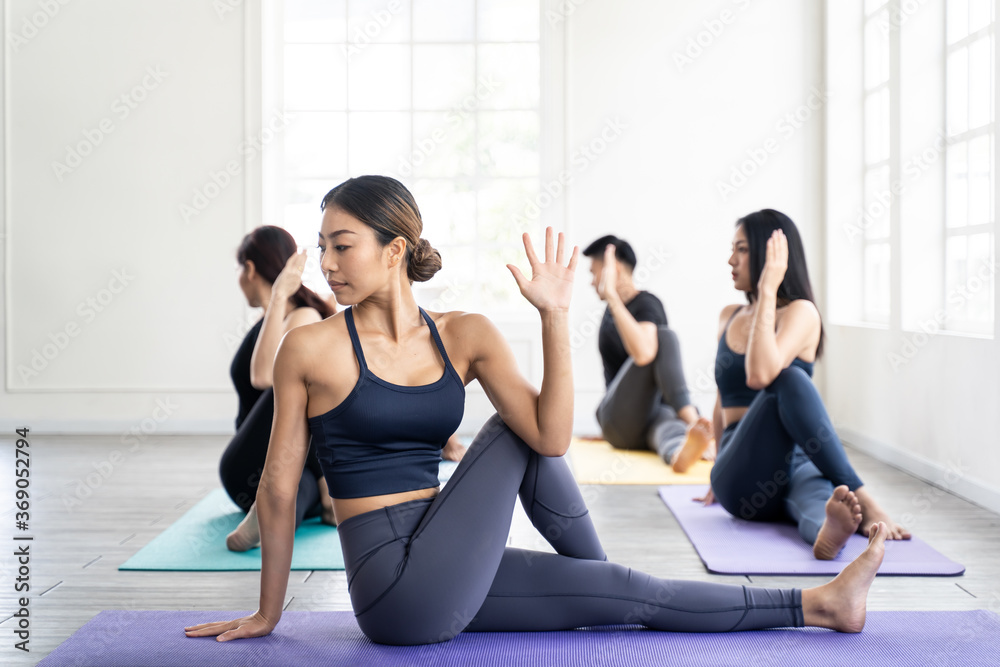 Obraz premium Asian group sporty people learning yoga lesson with coach trainer.