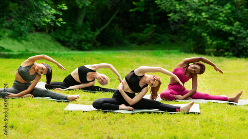 Yoga for inner harmony. Multinational women on their morning practice at park