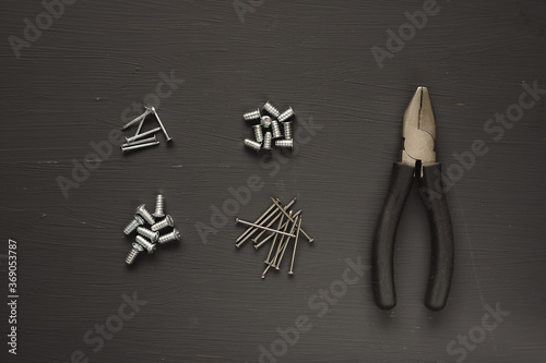 Pliers bolts and nails in a set on a gray background. Repair kit
