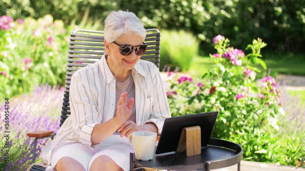 technology, old age and people concept - happy smiling senior woman with tablet pc computer having video call and waving hand at summer garden technology, old age and people concept - happy smiling senior woman with tablet pc computer having video call and waving hand at summer garden