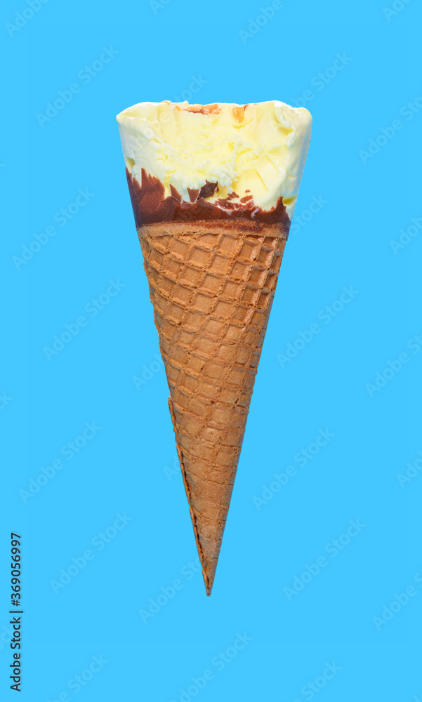 side view vanilla flaovr ice cream cone with a bite on a blue background side view vanilla flaovr ice cream cone with a bite on a blue background