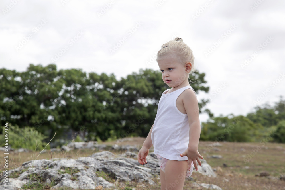 Outdoor candid portrait of two years old girl on tthe meadow. Outdoor candid portrait of two years old girl on tthe meadow.