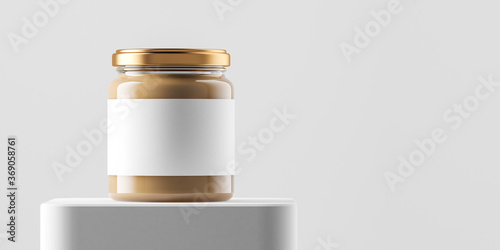 Bild auf Leinwand Transparent glass jar with copper metal cap and blank label filled by nut butter on the podium over white background
