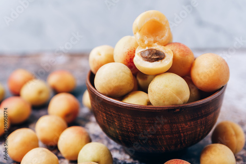 Lots of ripe yellow apricots close up in a crockery on the table