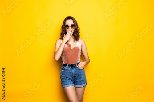 Shocked surprised girl in sunglasses and a summer hat, on a yellow background. Travel, vacation, summer © dianagrytsku