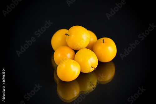 yellow cherry plums on the black background