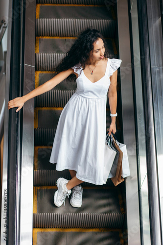 Young woman with bags on escalator