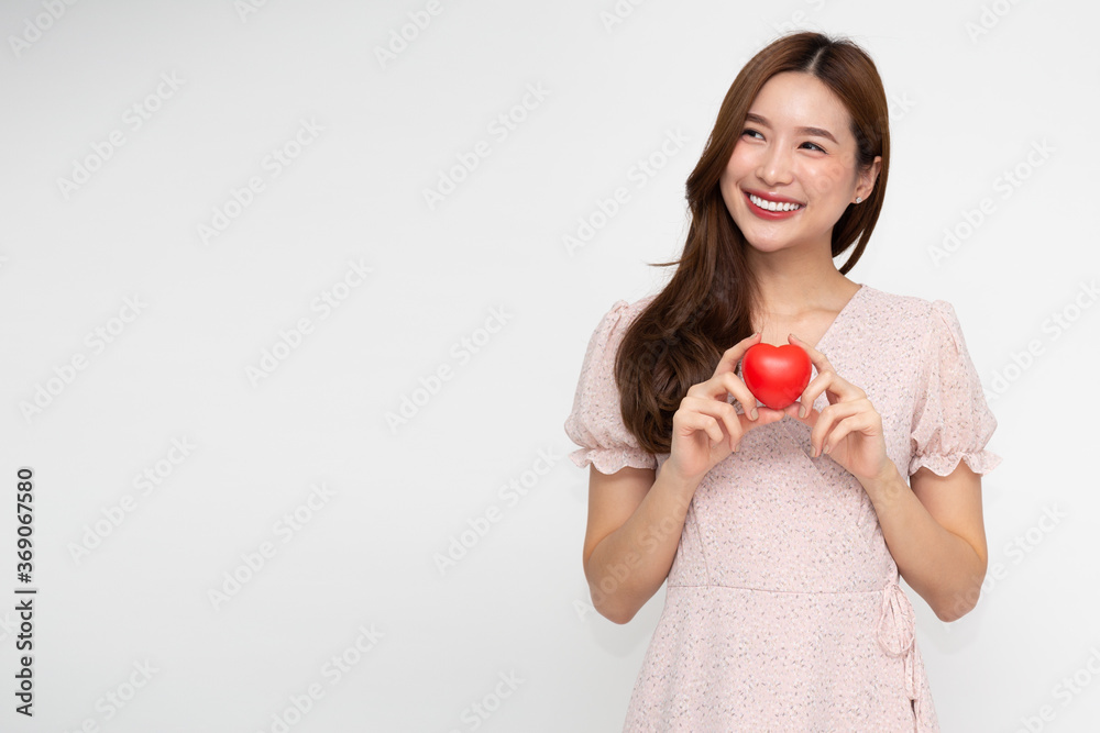 Attractive young Asian woman holding red love heart isolated on white background Attractive young Asian woman holding red love heart isolated on white background