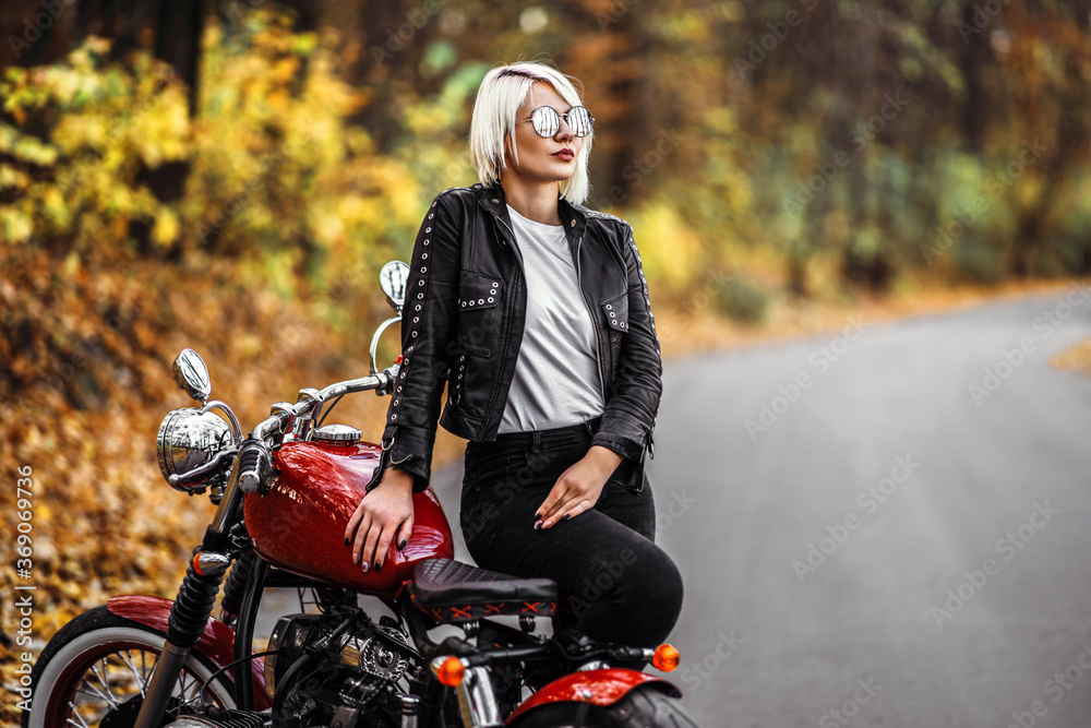Pretty blonde biker girl in sunglasses with red motorcycle on the road in  the forest Stock Photo | Adobe Stock