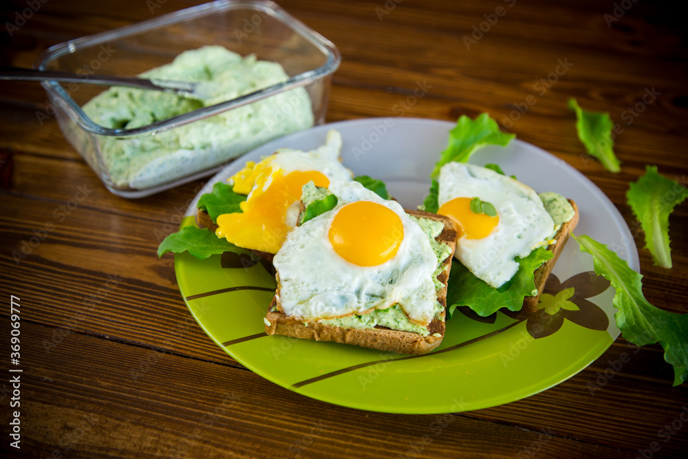 fried toast with cheese spread of arugula and fried egg in a plate fried toast with cheese spread of arugula and fried egg in a plate
