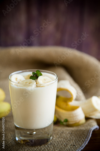 tasty homemade yogurt with bananas in a glass on a wooden table