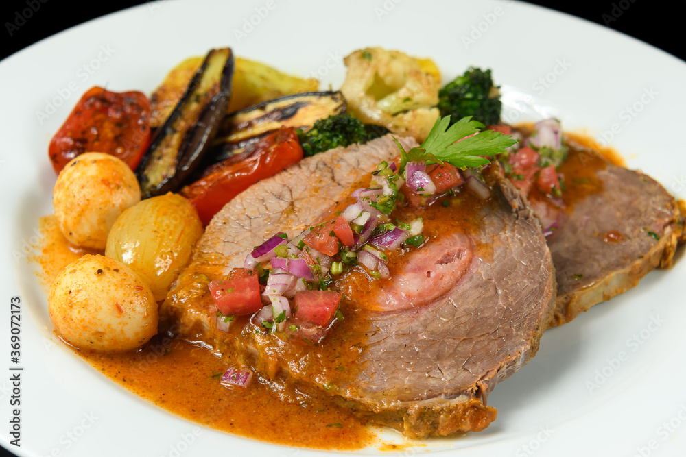   a dish with meat stuffed with smoked sausage served with grilled vegetables