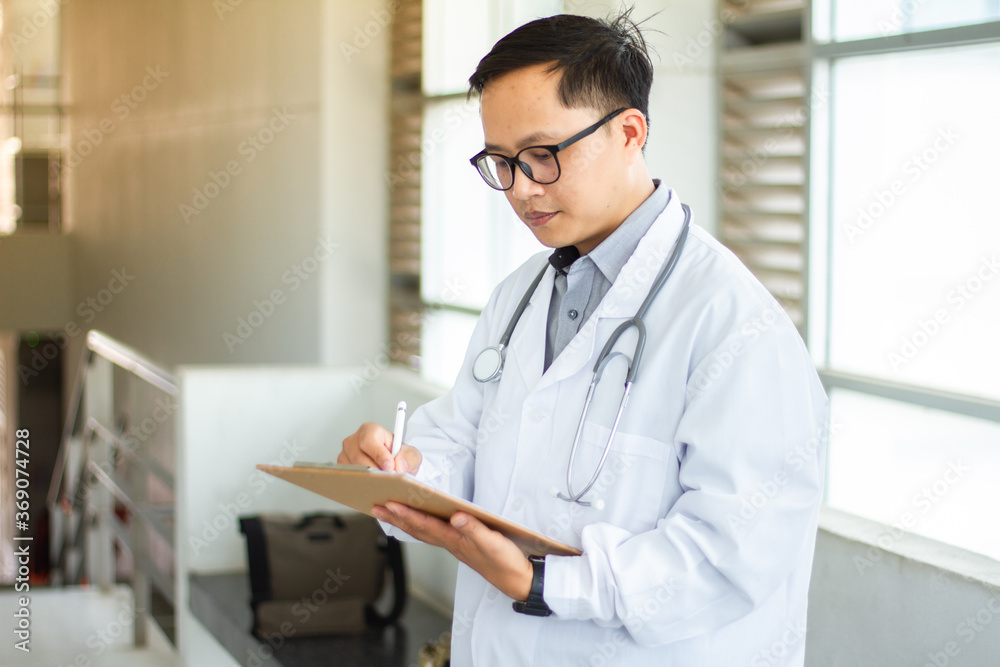 Close-up of a doctor filling out a medical form on the clipboard to work in a hospital or clinic. Close-up of a doctor filling out a medical form on the clipboard to work in a hospital or clinic.