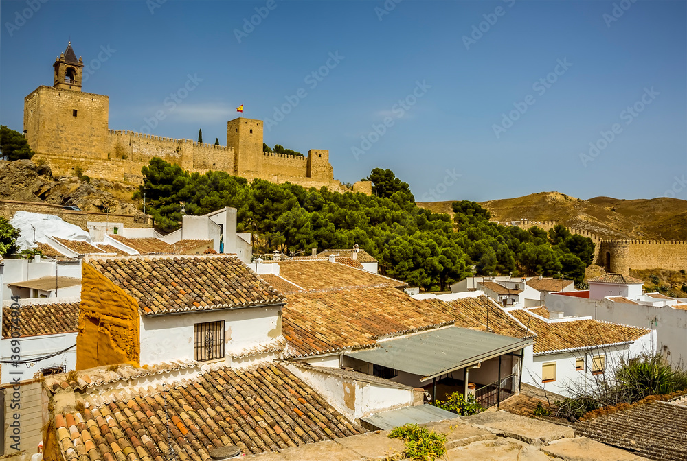 The Alcazaba of Antequera, Spain stands above the rooftops of the town on a summers morning