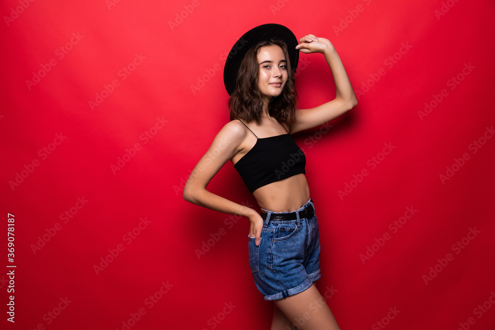 Portrait of woman wearing in floppy hat and sunglasses isolated over red background Portrait of woman wearing in floppy hat and sunglasses isolated over red background