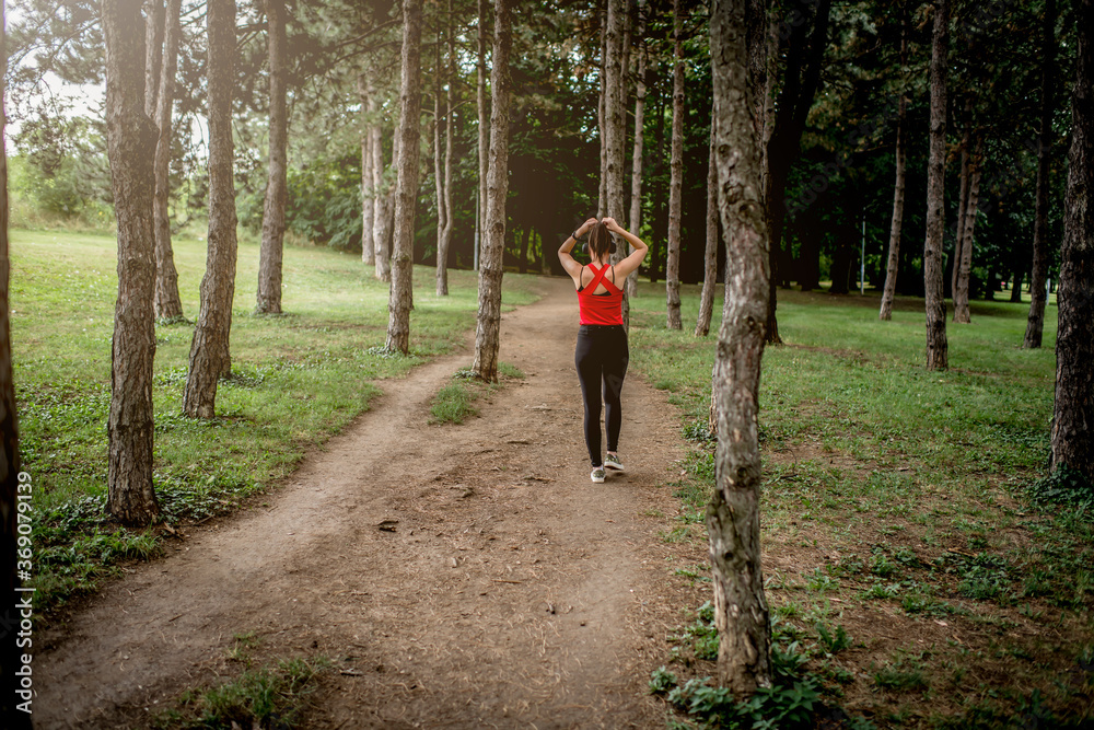 Young sporty woman jogging through the forest Young sporty woman jogging through the forest