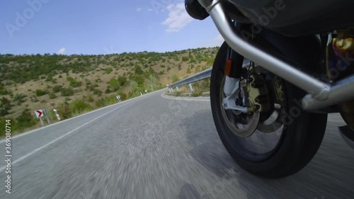 Motorcycle ridind on a road in nature. Close up wheel on a bumpy asphalt road. Speed up video photo