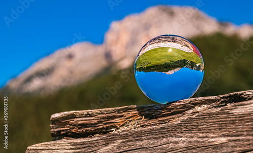 Crystal ball alpine landscape shot on a wooden block at the famous Mariä Heimsuchung sanctuary, Ettenberg, Berchtesgaden, Bavaria, Germany photo