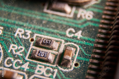 dusty printed circuit Board with components . macro selective focus photo