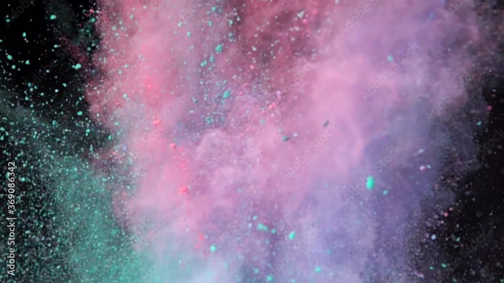 Super slow motion explosion of colorful multicolored powder on dark isolated background. Lumps of powder fly upwards and mix with the smoke.