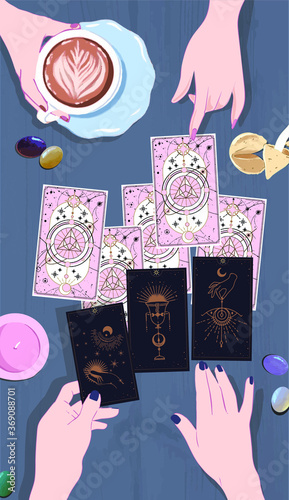 A session with a fortune teller with tarot cards, the interpreter's female hands lay out the suits of cards of fate for their guest, drink coffee and wait on arcane cards at the mystical guide
