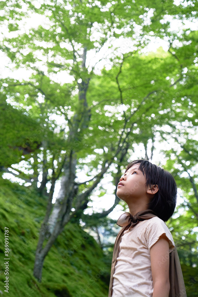Asian little girl looking up to the sky in a quiet garden Asian little girl looking up to the sky in a quiet garden