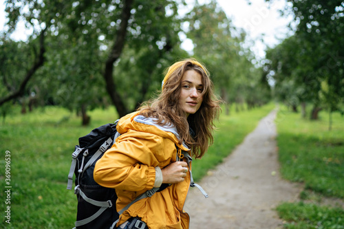 Beautiful young woman in a yellow jacket with a backpack