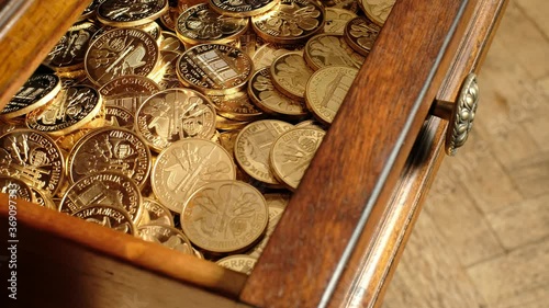 Female hand opening a drawer full of bullion gold coins.