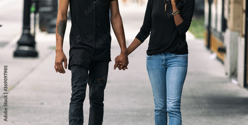 Holding Hands And Walking Down A City Sidewalk