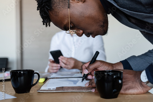 Focused African American businessman correcting chart