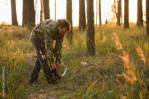 Adult man hunting with a recurved crossbow in the forest on an autumn day. photo