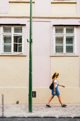 woman in a short denim overall walking down the street