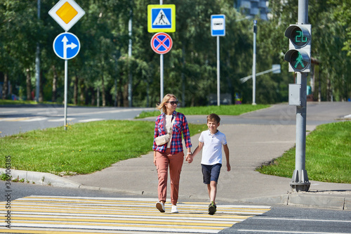 Woman and child cross road at crosswalk