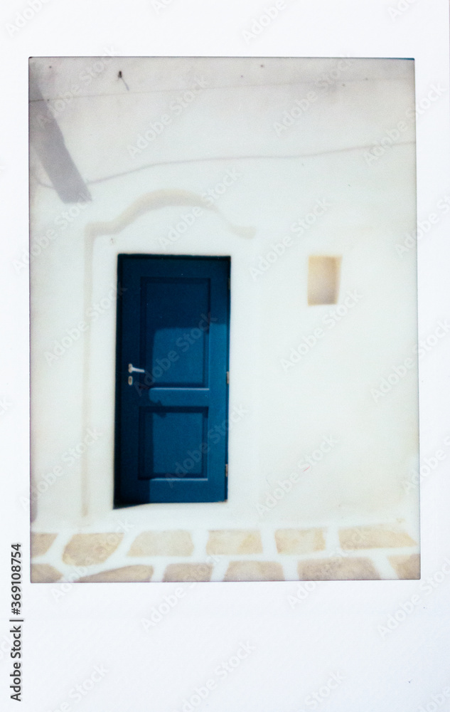 Instant photo of a blue door in Paros Island, Greece