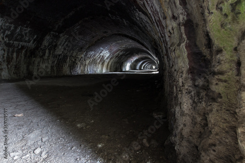 Langcliffe lime kiln in Settle, Yorkshire. Old, dark stone tunnel with arches and interesting light