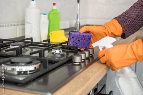 person with glove and cleaning set wash kitchen furniture. protect yourself