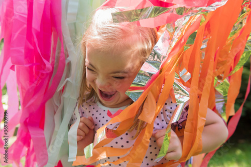 Joyful girl with down syndrome running through streamers photo