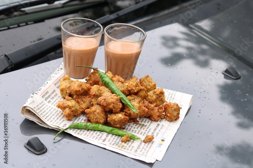 Crispy moong pakora, delicious street food, favourite indian snack in monsoon served with Hot Tea.Kept on car's bonnet