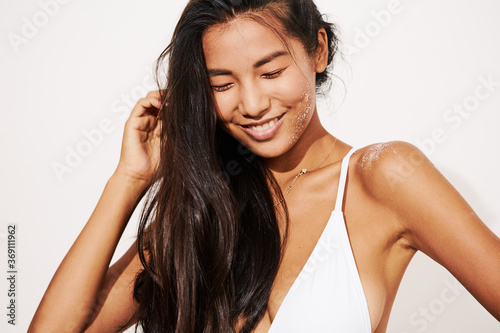 Stunning Asian Woman Smiling Portrait - Sun protection concept - Beach salty hair with Sand on Skin photo