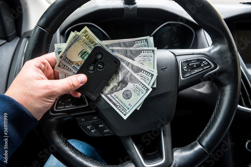 Car key and dollar in hand inside auto © RomanR