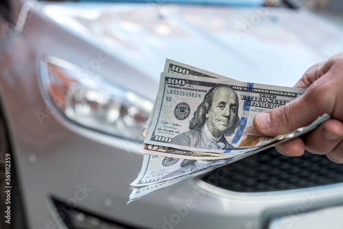 man doing purchase or rent car giving dollar salesman