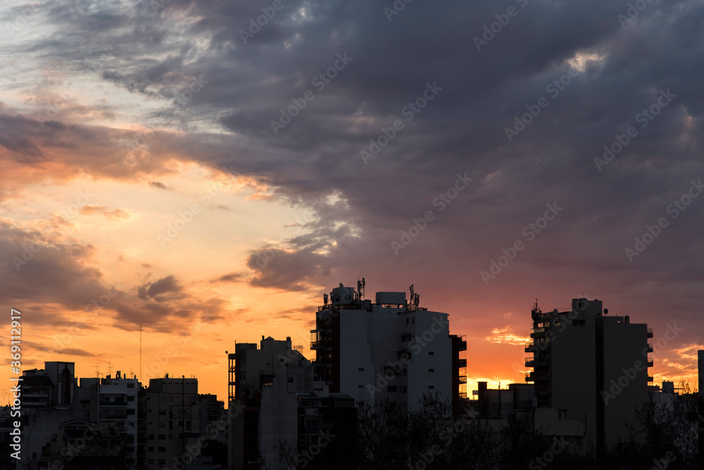 Sunset in Buenos Aires, Argentina. Orange and cloudy sky over some buildings