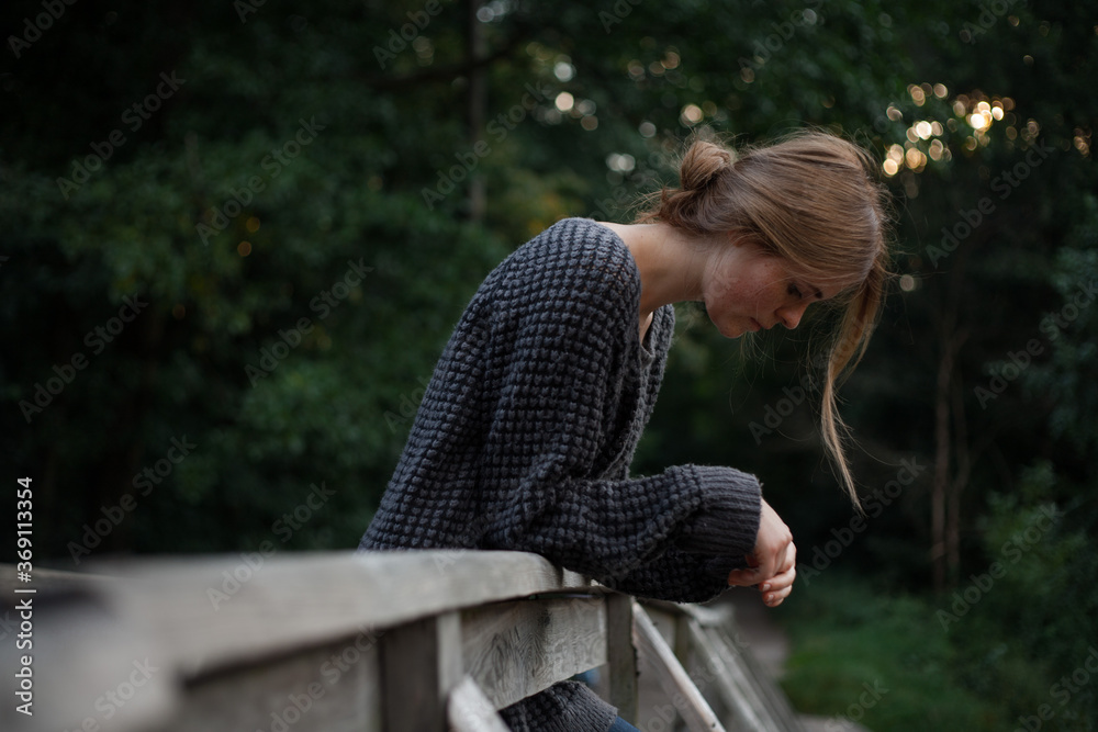 photo of sad girl in neutral clothes on the bridge photo of sad girl in neutral clothes on the bridge